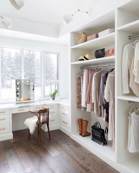 an ethereal cloffice with a large white open closet and a built in desk or vanity table plus a gorgeous view