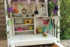 an outdoor kids’ play kitchen with an additional sand box that can be hidden as it’s a drawer or pulled out when needed