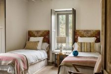 02 a boho rustic shared guest bedroom with patchwork headboards, neutral bedding and a lovely chair next to them