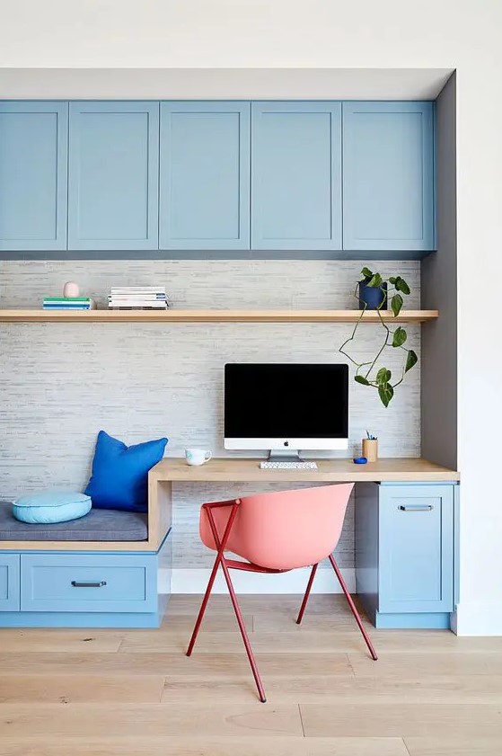 a bright blue home office done with kitchen cabinetry, a small desk and a daybed, a floating shelf is a very welcoming and fresh idea