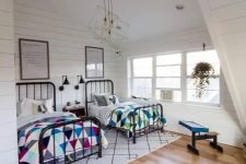 09 a cozy and large attic bedroom with two beds and colorful textiles plus geometric ceiling lamps