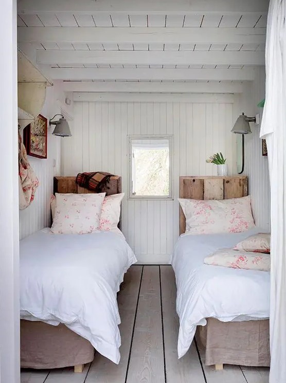 a cozy vintage inspired guest bedroom with twin beds and wooden floors, walls and a ceiling