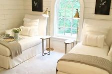 14 a cozy vintage-inspired guest bedroom with two beds, brass lamps and an arched window