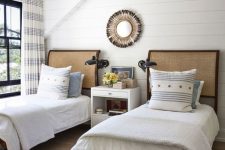 15 a farmhouse bedroom with planked walls and a ceiling, dark-stained beds with neutral bedding, a white nightstand and printed textiles