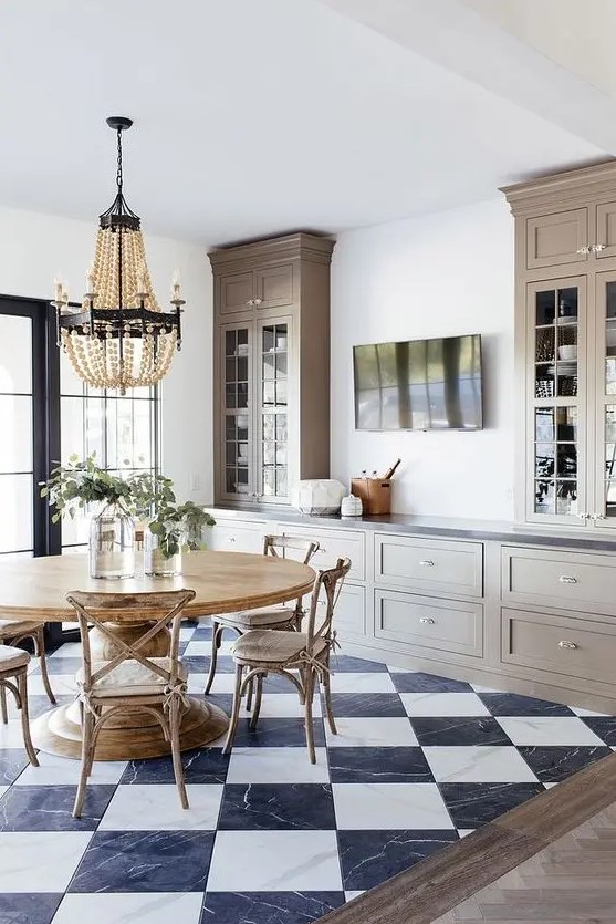 a beautiful farmhouse dining room done with grey kitchen cabinets, a wooden dining set and a wooden bead chandelier