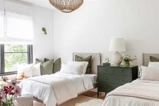 27 a neutral farmhouse shared guest bedroom with matching beds, neutral bedding, layered rugs, a black dresser, a woven pendant lamp