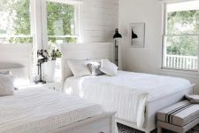 28 a neutral shared bedroom with a planked accent wall, white planked matching beds, neutral bedding, striped benches and a bead chandelier
