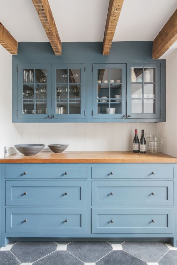 a blue home bar done with kitchen cabinets, wooden beams and a wooden countertop is a stylish diea for any home