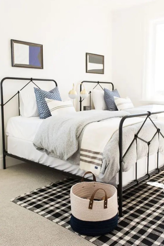 a stylish gender neutral guest bedroom with two beds and touches of black here and there for drama