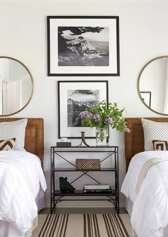 a stylish gender-neutral guest bedroom with leather upholstered beds and round mirrors plus artworks