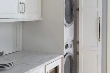 38 a neutral laundry with shaker style kitchen cabinets, neutral stone countertops and much storage space is lovely