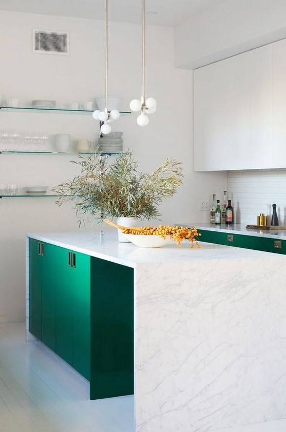 a beautiful emerald and white kitchen with a white tile backsplash and a gorgeous white stone waterfall countertop plus chic pendant lamps