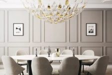 a beautiful greige dining room with paneled walls, a large oval table, greige chairs, a beautiful glass chandelier