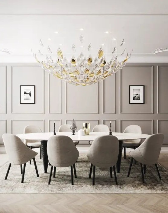 a beautiful greige dining room with paneled walls, a large oval table, greige chairs, a beautiful glass chandelier