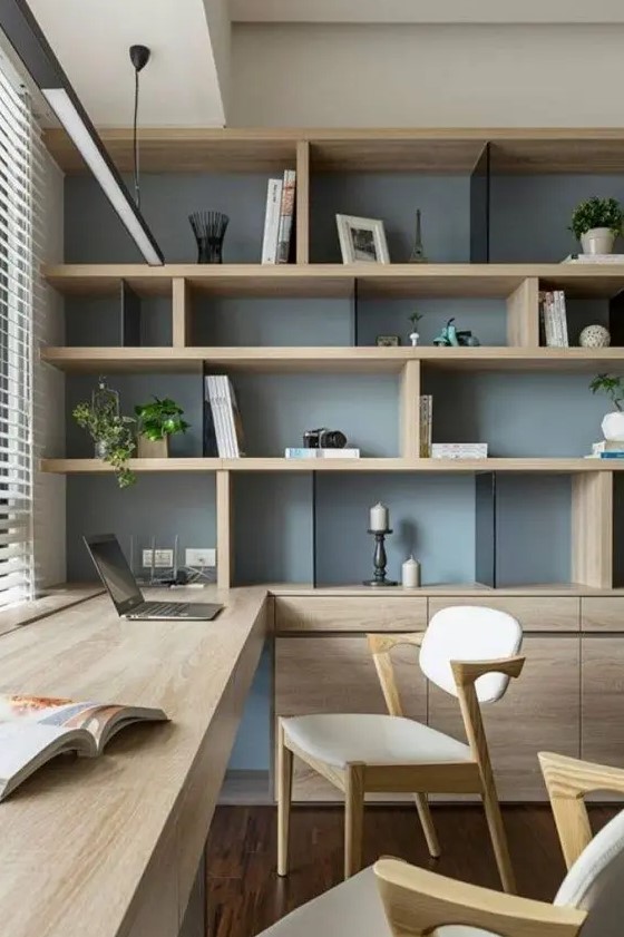 a chic contemporary home office with a storage unit that takes a whole wall, with open and closed storage compartments, a built in desk and chic modern chairs