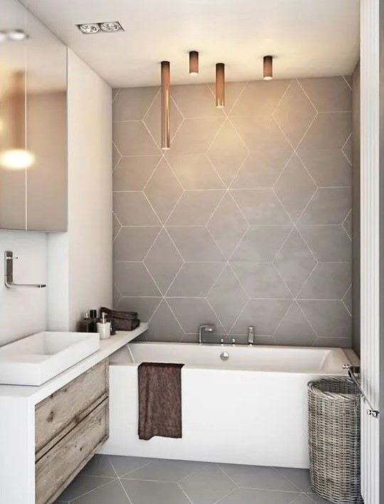 a contemporary bathroom with greige geo tiles and a floor, a built in vanity, a built in tub a mirror cabinet and tube lighting
