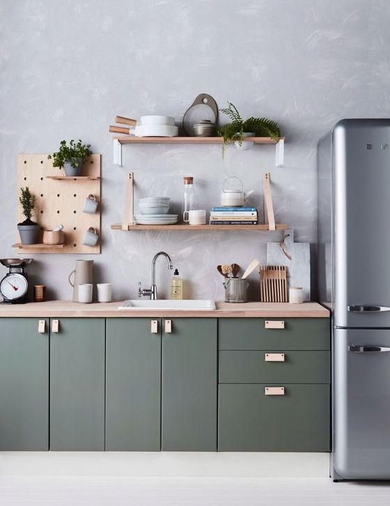a contemporary dark green kitchen with a wallpaper wall, plywood shelving and a grey fridge is chic and stylish