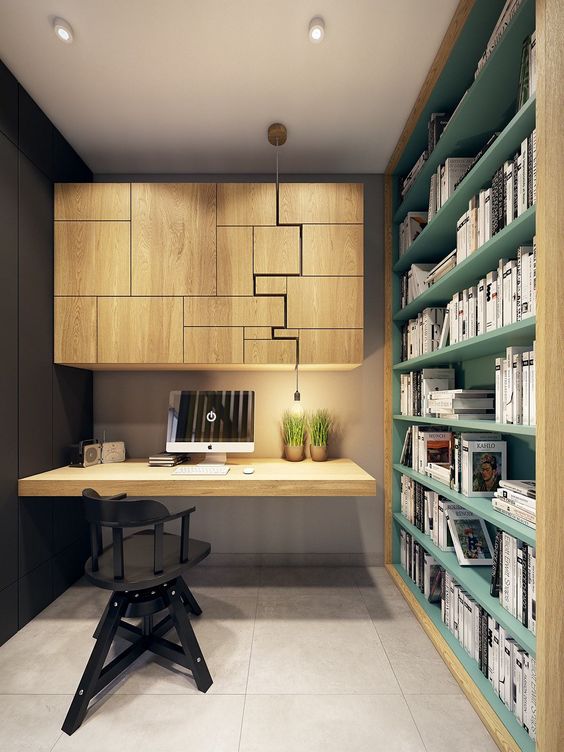 a contemporary home office with a catchy jigsaw storage unit, a built in green storage shelf, a floating desk and a black chair