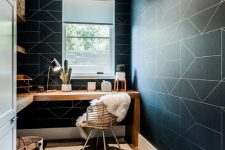 a contemporary home office with black geo wallpaper walls, a corner desk and a rattan chair plus modern lamps