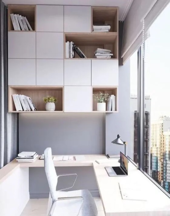 a contemporary light-filled home office in front of a glazed wall, with sleek white and stained furniture, open and closed compartments and a built-in desk