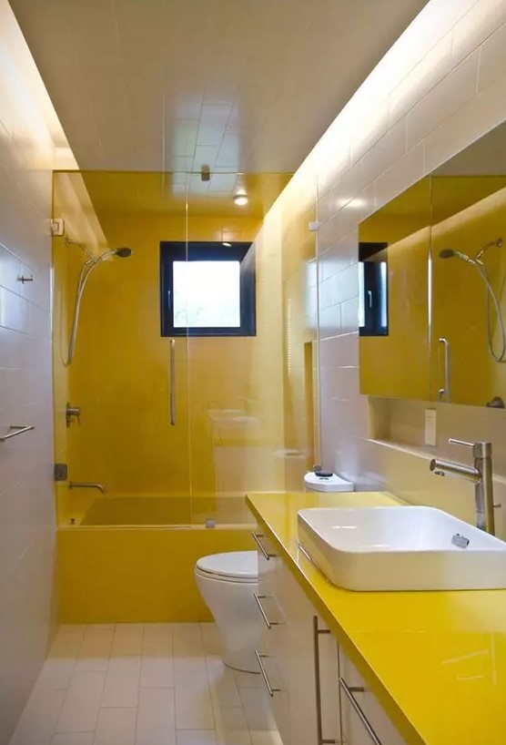 a contemporary neutral and yellow bathoom with pretty square tiles, a yellow and white vanity, a window that gives light and a lit up ceiling