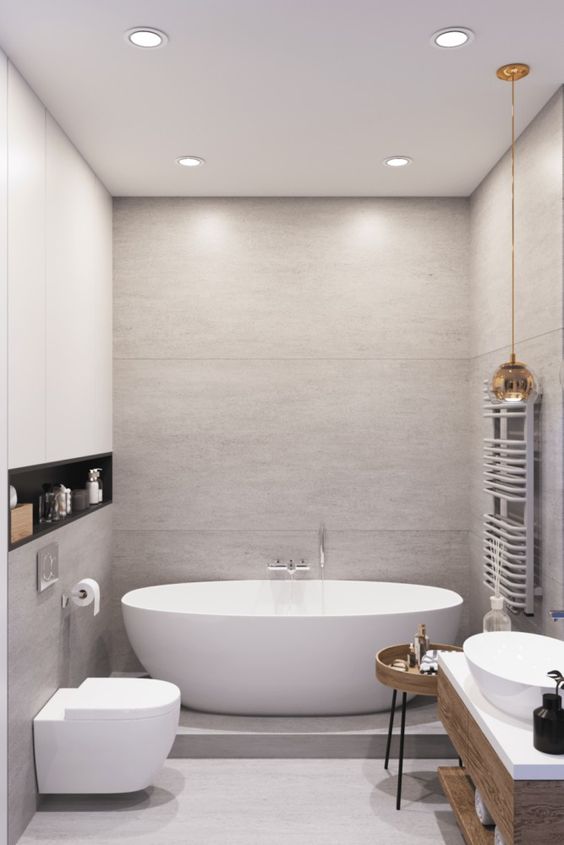 a contemporary neutral bathroom with large scale panels, white appliances, a stained side table and built-in lights