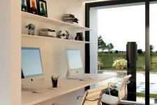 a contemporary shared home office nook by a glazed wall, with a floating desk, white chairs, open shelves and a lovely view