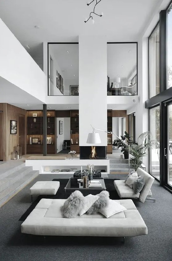 a contemporary to minimalist living room with a built in fireplace, a glass table, white seating furniture and a potted plant is amazing