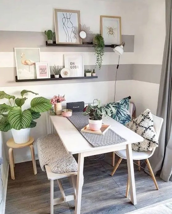a cute and cozy dining nook with a table, chairs and a bench, open shelves, some artworks, potted greenery is lovely