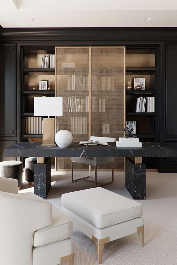 a luxurious contemporary home office with a black storage unit that takes the whole wall, cane doors, a black marble desk and a creamy chair