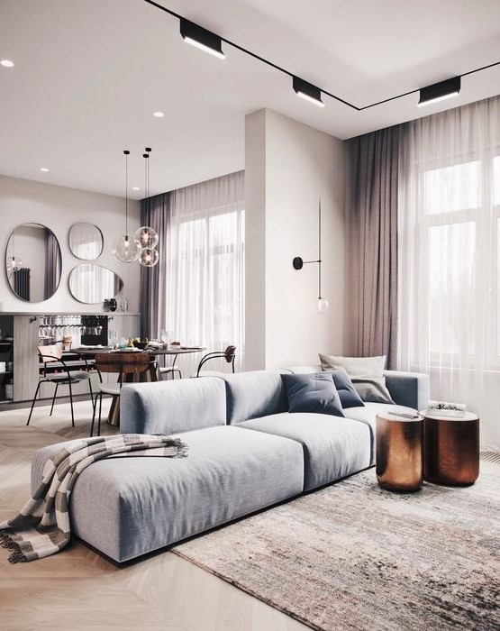 a luxurious contemporary space with a light blue low sofa, metallic stools or side tables and touches of dusty pink