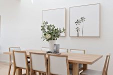 a minimalist neutral dining space with a stained table and chairs, a mini gallery wall and some greenery is amazing