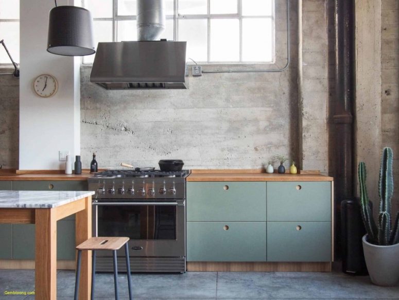 a modern industrial kitchen with blue plywood and timber cabinets with no hardware, whitewashed brick walls and a pendant lamp