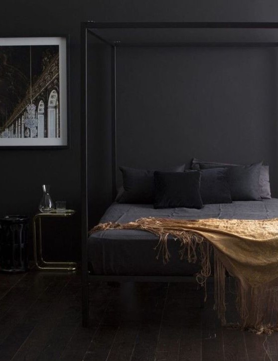 a moody contemporary bedroom with black walls, a black cnaopy bed, chic nightstands and a bold artwork