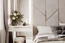 a neutral luxurious bedroom with a grey and metallic accent wall, a grey upholstered bed, a floating nightstand and a tall mirror