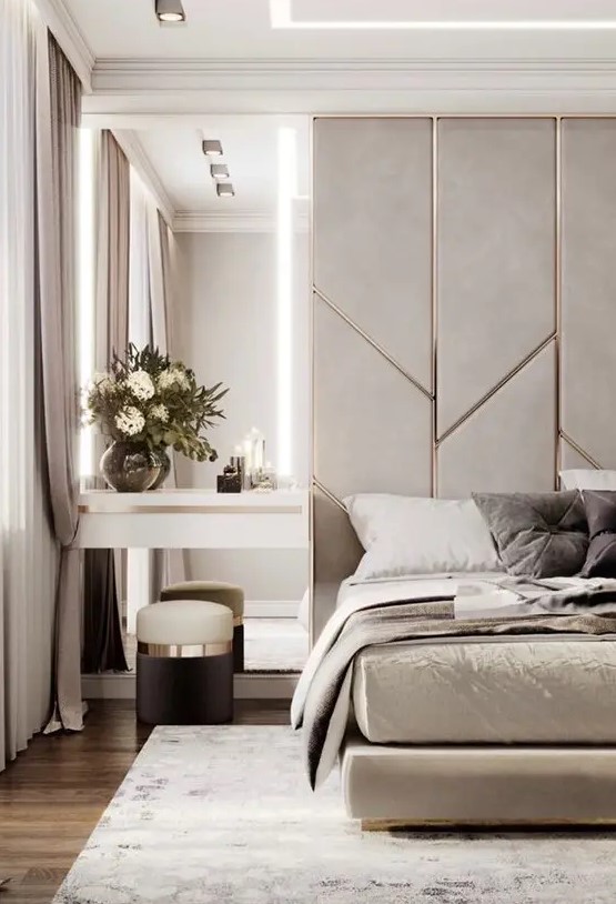 a neutral luxurious bedroom with a grey and metallic accent wall, a grey upholstered bed, a floating nightstand and a tall mirror