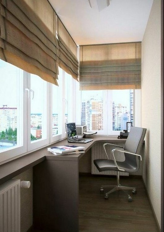 a small balcony home office with a built-in desk, a comfy chair, shades and everything necessary is a great idea