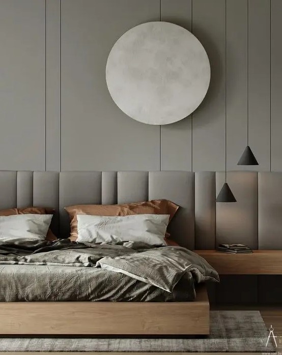 a striking contemporary bedroom in greys, with a grey accent wall, a wooden bed with an extended headboard and pendant lamp