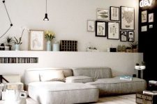 a stylish contemporary living room with a black accent wall, a low grey sofa, a raised shelf with potted plants and a gallery wall