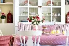a sweet vintage meets shabby chic dining room with white furniture, cute printed textiles, a white buffet with chic porcelain