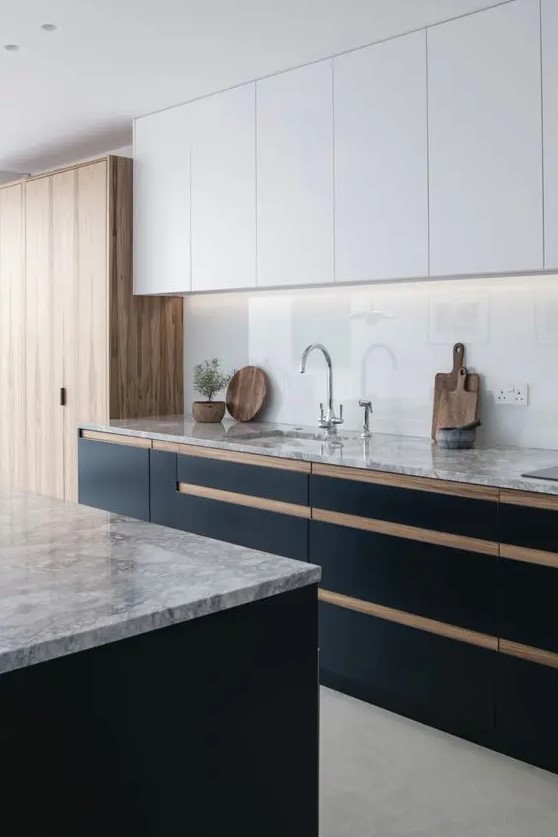 a trendy two tone kitchen with matte white and black cabinets, grey countertops and a white glass backsplash with additional lights
