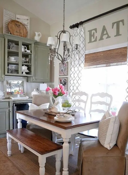 a vintage rustic dining space with a table with a stained tabletop, benches and matching white chairs, a lovely pendant lamp