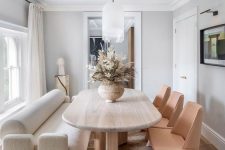 a welcoming neutral dining room with a stained table, a large creamy sofam beige leather chairs and pendant lamps