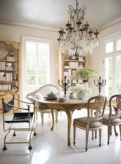 an exquisite vintage dining room with chic buffets, a vintage dining table and vintage chairs, a loveseat and a statement crystal chandelier