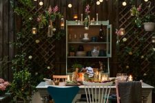 03 a backyard dining space with string lights over the space and candle lanterns on the table plus florals around