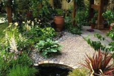 03 a lovely outdoor space with pebbles and brick, with a small pond with water plants and various greenery around looks eye-catchy
