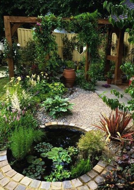 a lovely outdoor space with pebbles and brick, with a small pond with water plants and various greenery around looks eye-catchy