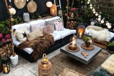 05 a boho backyard with candle lanterns, string lights and paper lamps over the space, potted blooms and greenery around