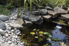 06 a small pond with water lilies and pebbles and rocks around is a beautiful water feature for a garden