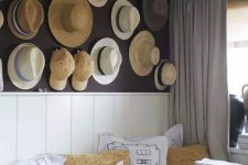 07 a farmhouse space with a whole wall of straw hats and baseball caps that adds eye-catchiness to the space and makes it warm and cool